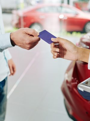 Close-up image of man paying with credit card for rental car